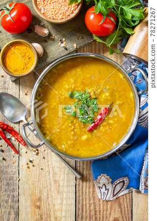 Indian food, a real Indian dish. Traditional Indian spicy lentil puree soup with herbs on a rustic table. Top view flat lay background. Copy space. Indian food, a real Indian dish. Traditional Indian spicy lentil puree soup with herbs on a rustic table. Top view flat lay background. Copy space. 78271267