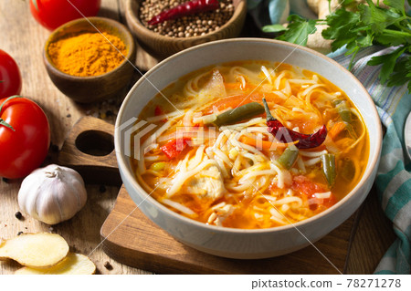Tukpa soup of Indian cuisine. Hot noodle soup with chicken, ginger, cilantro and spices on a deyven wooden table. Tukpa soup of Indian cuisine. Hot noodle soup with chicken, ginger, cilantro and spices on a deyven wooden table. 78271278