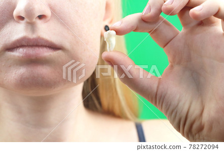 Blurry pose of a woman with toothache and a hand holding the extracted tooth, hocus on the hand Blurry pose of a woman with toothache and a hand holding the extracted tooth, hocus on the hand 78272094
