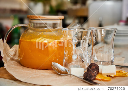 Sea buckthorn tea in a transparent glass teapot. Close-up, selective focus Sea buckthorn tea in a transparent glass teapot. Close-up, selective focus 78275020
