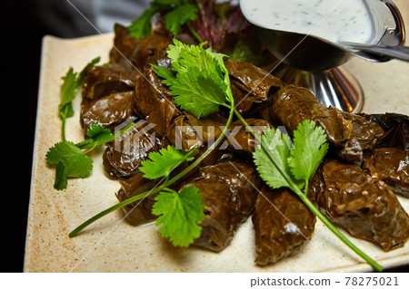 Dolma with spicy sour cream sauce. Close-up, selective focus 78275021