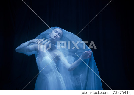 Despair. Young graceful balerina in image of ghost bride in art performance isolated on dark background in neon light. Despair. Young graceful balerina in image of ghost bride in art performance isolated on dark background in neon light. 78275414
