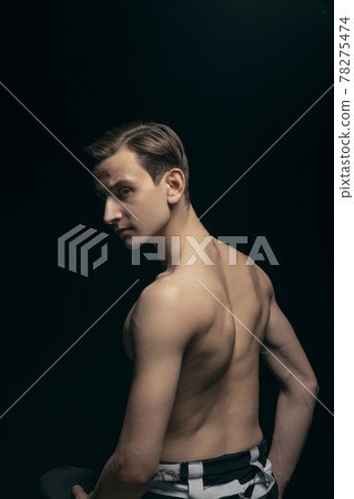 Portrait of young handsome man, fashion model posing isolated on dark background. Beauty, fashion, inspiration concept. 78275474