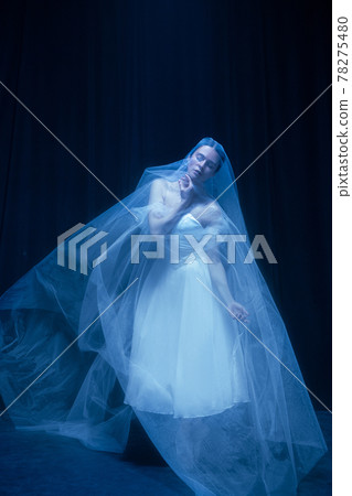 Young woman in wedding dress and man, two ballet dancers in art performance dancing isolated over dark background. Young woman in wedding dress and man, two ballet dancers in art performance dancing isolated over dark background. 78275480