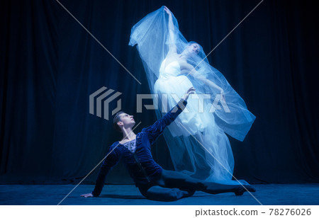Young woman in wedding dress and man, two ballet dancers in art performance dancing isolated over dark background. Young woman in wedding dress and man, two ballet dancers in art performance dancing isolated over dark background. 78276026