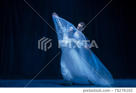 Young woman in wedding dress and man, two ballet dancers in art performance dancing isolated over dark background. 78276102