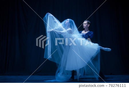 Young woman in wedding dress and man, two ballet dancers in art performance dancing isolated over dark background. Young woman in wedding dress and man, two ballet dancers in art performance dancing isolated over dark background. 78276111
