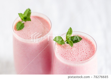 Two glasses of strawberry milkshake. Two glasses of strawberry milkshake. 78276685