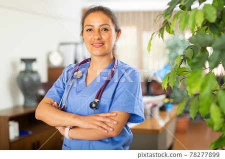 Smiling young female health worker standing in medical office 78277899