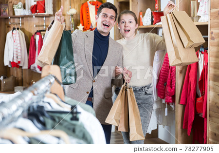 Young woman and man are standing satisfied with packadge after shopping Young woman and man are standing satisfied with packadge after shopping 78277905