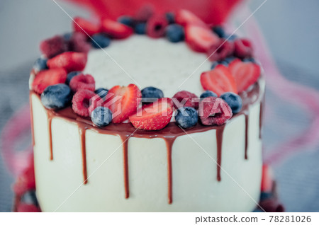 Chocolate cake with whipped cream and fresh berries. Close up. Sponge cake with strawberries and vanilla cream. Chocolate cake with whipped cream and fresh berries. Close up. Sponge cake with strawberries and vanilla cream. 78281026