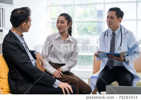 A young Asian couple is consulting with a doctor about pregnancy planning.The doctor is reporting the health check-up to the couple and explaining the treatment guidelines, taking care of the health. A young Asian couple is consulting with a doctor about pregnancy planning.The doctor is reporting the health check-up to the couple and explaining the treatment guidelines, taking care of the health. 78281413