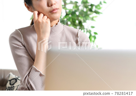 一位年輕女子在筆記本電腦前擔心（思考） 78281417