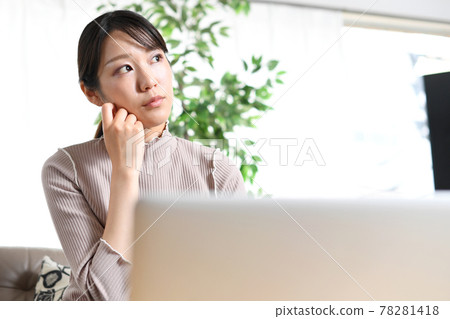 一位年輕女子在筆記本電腦前擔心（思考） 78281418
