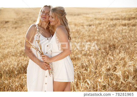 Mother with beautiful daughter in a autumn field Mother with beautiful daughter in a autumn field 78281965