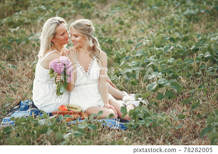 Mother with beautiful daughter in a autumn field Mother with beautiful daughter in a autumn field 78282005