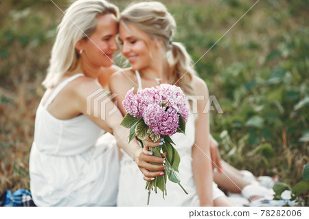 Mother with beautiful daughter in a autumn field Mother with beautiful daughter in a autumn field 78282006