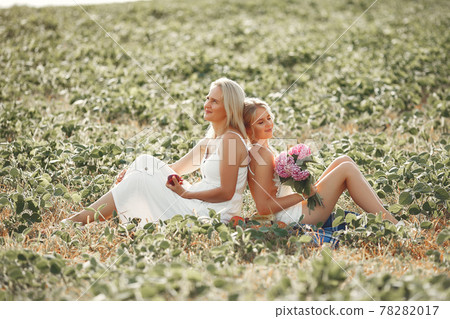 Mother with beautiful daughter in a autumn field Mother with beautiful daughter in a autumn field 78282017