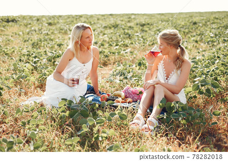 Mother with beautiful daughter in a autumn field Mother with beautiful daughter in a autumn field 78282018