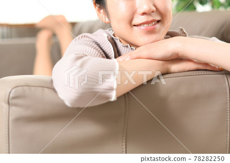 一個年輕的女人在沙發上放鬆 一個年輕的女人在沙發上放鬆 78282250