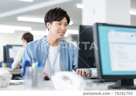 一位年輕的商人在辦公室上網時操作電腦 78282793
