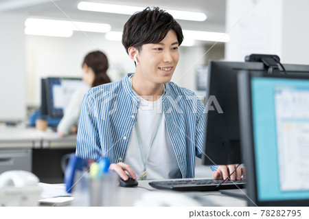 一位年輕的商人在辦公室上網時操作電腦 一位年輕的商人在辦公室上網時操作電腦 78282795