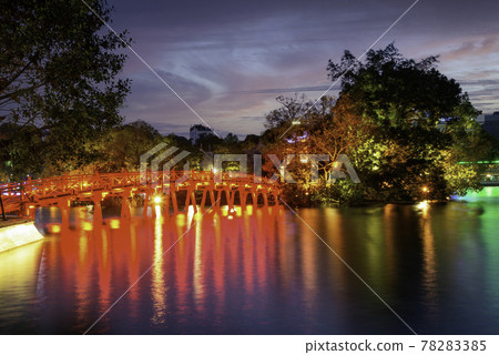 Hanoi Red Bridge at night. The wooden red-painted bridge over the Hoan Kiem Lake connects the shore and the Jade Island on which Ngoc Son Temple stands Hanoi Red Bridge at night. The wooden red-painted bridge over the Hoan Kiem Lake connects the shore and the Jade Island on which Ngoc Son Temple stands 78283385