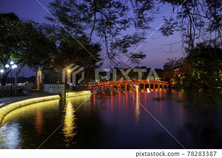 Hanoi Red Bridge at night. The wooden red-painted bridge over the Hoan Kiem Lake connects the shore and the Jade Island on which Ngoc Son Temple stands Hanoi Red Bridge at night. The wooden red-painted bridge over the Hoan Kiem Lake connects the shore and the Jade Island on which Ngoc Son Temple stands 78283387