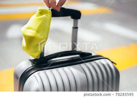 Hand holding travel case and face mask 78283595