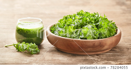 Healthy green kale smoothie with kale salad on wooden board Healthy green kale smoothie with kale salad on wooden board 78284055