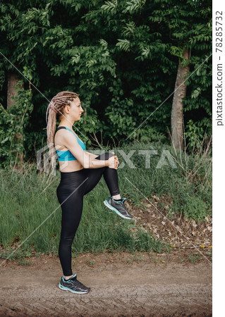 Fit sporty woman in sportswear stretching legs Fit sporty woman in sportswear stretching legs 78285732