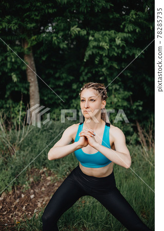 Beautiful sporty woman stretching body in nature 78285735