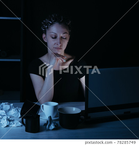 Night work. Woman drinking coffee working late Night work. Woman drinking coffee working late 78285749