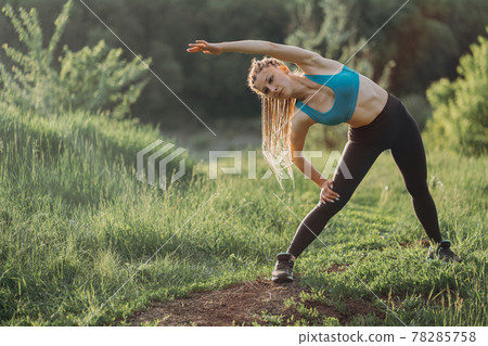 Fit sporty woman doing morning workout outdoors Fit sporty woman doing morning workout outdoors 78285758