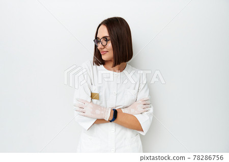 Beautiful doctor looking away while posing on camera over white background with copy space 78286756