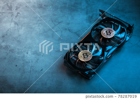On the powerful fans of the video card there are coins of the Bitcoin cryptocurrency with a green backlight On the powerful fans of the video card there are coins of the Bitcoin cryptocurrency with a green backlight 78287019