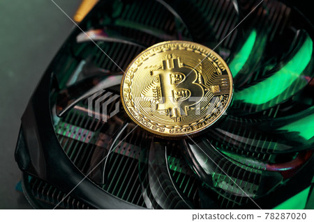 Gold bitcoin on the video card cooler with green neon lighting in the Cyberpunk style. Gold bitcoin on the video card cooler with green neon lighting in the Cyberpunk style. 78287020