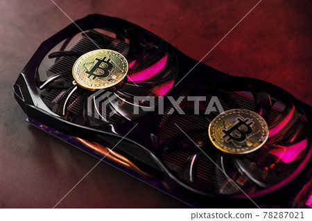On the fans of a powerful video card, the coins of the Bitcoin cryptocurrency with a red backlight are displayed. 78287021
