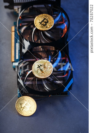 Bitcoin coin on a powerful graphics card for mining and earning cryptocurrency concept on a dark background. Bitcoin coin on a powerful graphics card for mining and earning cryptocurrency concept on a dark background. 78287022