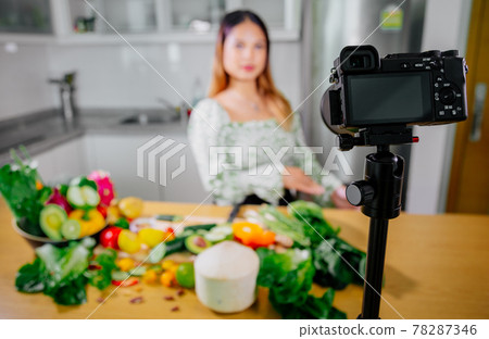 Asian woman blogger or content creator cooking and recording video camera. showing healthy food 78287346