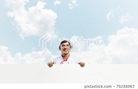 Young male chef with blank signboard 78288063