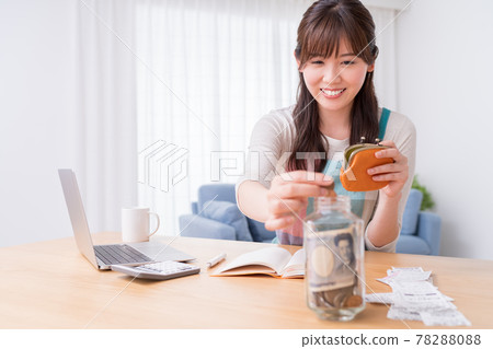 A woman who keeps a household account book and stores coins in a small bottle 78288088