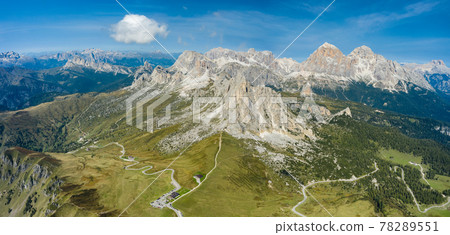 Aerial view of Giau Pass and mountain peaks at daylight. Road to the mountain. Tofana mountain group in background. Italy Aerial view of Giau Pass and mountain peaks at daylight. Road to the mountain. Tofana mountain group in background. Italy 78289551