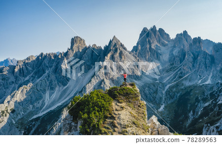 Aerial view of a man with raised hands on the top edge admiring epic Cadini di Misurina mountain peaks, Italian Alps, Dolomites, Italy, Europe Aerial view of a man with raised hands on the top edge admiring epic Cadini di Misurina mountain peaks, Italian Alps, Dolomites, Italy, Europe 78289563