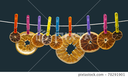 dried pieces of different citrus fruits hang on colored clothespins dried pieces of different citrus fruits hang on colored clothespins 78291901