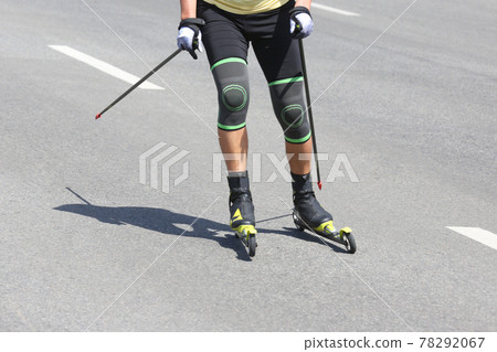 sportsman roller skis on the asphalt on the city road. Sports leisure sportsman roller skis on the asphalt on the city road. Sports leisure 78292067