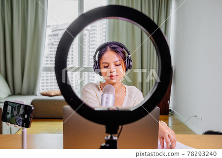 Asian blogger, podcaster or vlogger looking at camera and talking on video shooting with technology 78293240