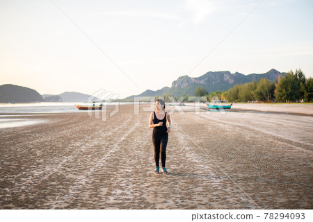 Happy asian woman running on the beach in the morning Happy asian woman running on the beach in the morning 78294093