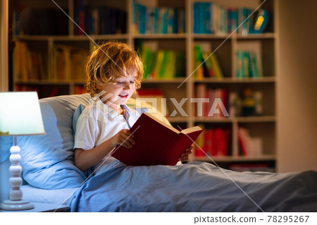 Child reading book in bed. Kids read at night. Child reading book in bed. Kids read at night. 78295267