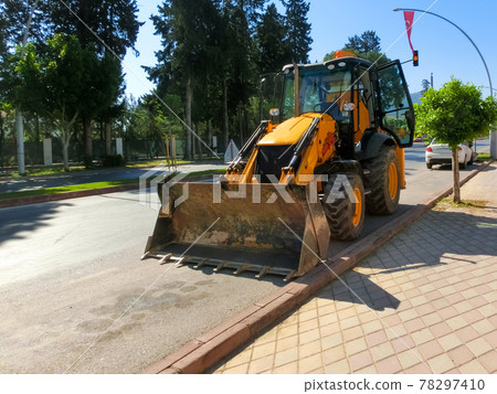 Mini bulldozer or excavation or loader on road. Mini bulldozer or excavation or loader on road. 78297410